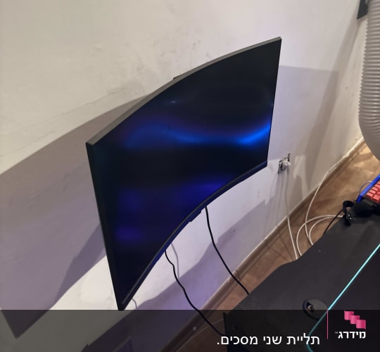מסך מחשב מותקן על קיר עם כבלים מחוברים